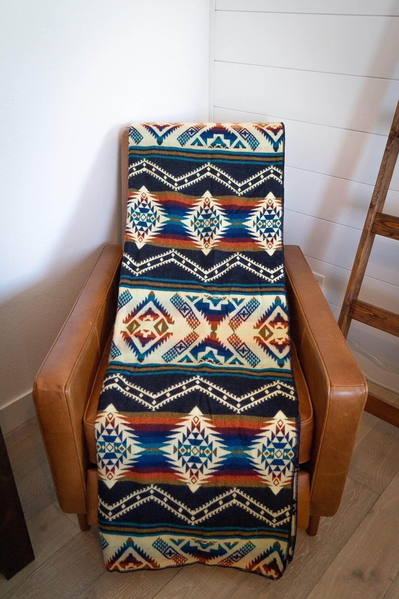 Sustainable bohemian alpaca blanket on brown armchair
